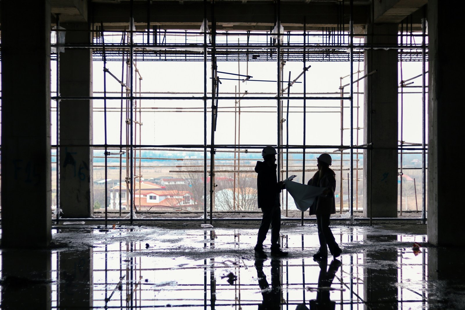 Two construction workers reviewing plans on a site in the UK